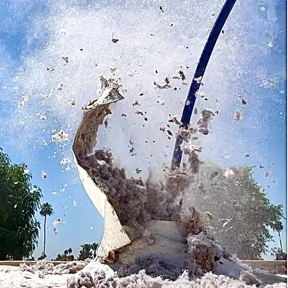 Lint blowing out of an exterior dryer vent during cleaning